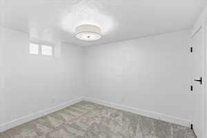 Empty room with a textured ceiling and carpet