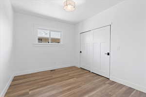 Unfurnished bedroom  with light wood-style floors and a closet