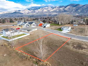 Aerial perspective of suburban area with mountains and property parcel outlined