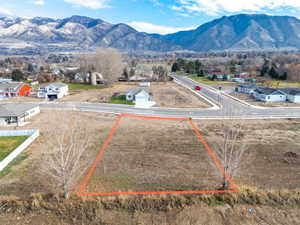 Aerial view of property's location with property parcel outlined and a mountainous background