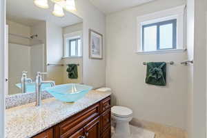 Bathroom with vanity, light tile patterned floors, and a shower