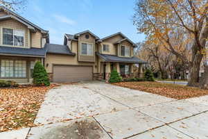 Craftsman-style house with stone siding, concrete driveway, a garage, covered porch, and roof with shingles
