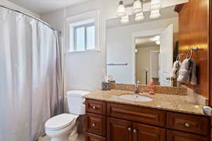 Full bathroom featuring curtained shower and vanity