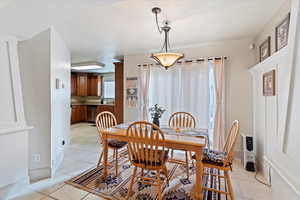 Dining space with light tile patterned flooring and baseboards