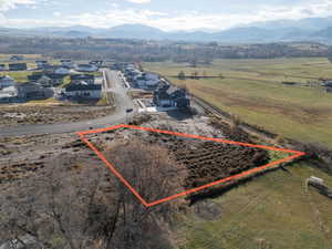 Overview of rural landscape with property boundaries highlighted and a mountainous background
