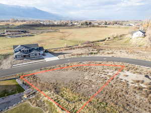Aerial view of sparsely populated area featuring property boundaries highlighted and a mountain backdrop