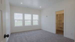 Spare room with light carpet and recessed lighting