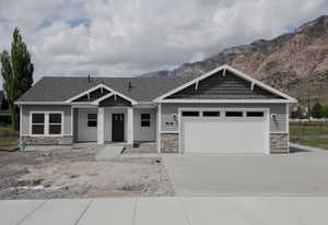 Craftsman inspired home with stone siding, a porch, concrete driveway, board and batten siding, and a mountain view
