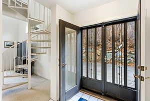 View of doors to patio and winding staircase to loft