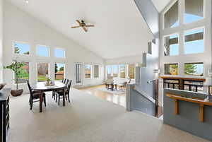 Dining space featuring high vaulted ceiling, healthy amount of natural light, and a ceiling fan