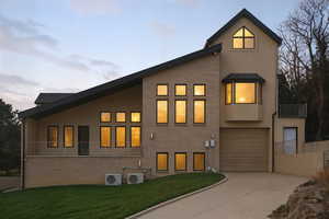 View of side of home with a balcony, driveway, and stucco siding