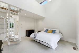 Primary suite bedroom with staircase leading to loft area