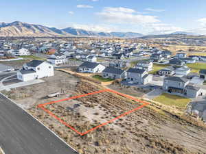 Aerial perspective of suburban area featuring property boundaries highlighted and a mountainous background