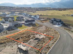 Aerial view of residential area with property parcel outlined and a mountain backdrop
