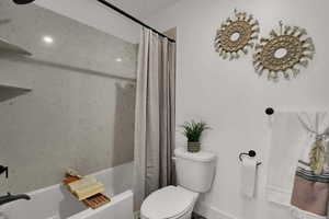 Bathroom featuring shower / bath combo and toilet