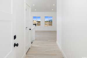 Hall with recessed lighting and light wood-style flooring