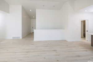 Empty room featuring light wood finished floors and recessed lighting