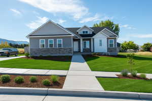 Craftsman-style house with a front yard and stone siding