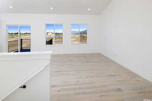 Empty room with plenty of natural light, light wood-type flooring, and recessed lighting