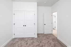 Unfurnished bedroom featuring carpet flooring and a closet