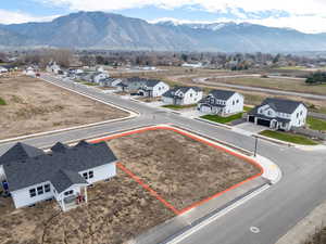 Aerial view of residential area featuring property parcel outlined and a mountainous background