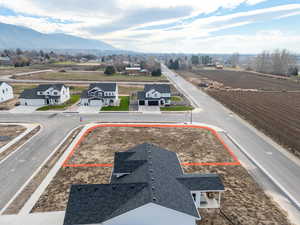 Aerial perspective of suburban area with property parcel outlined and a mountain backdrop