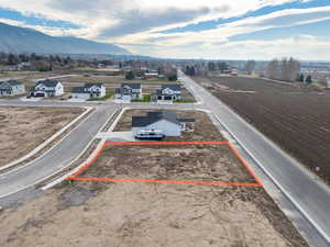 Aerial perspective of suburban area with property parcel outlined and a mountain backdrop