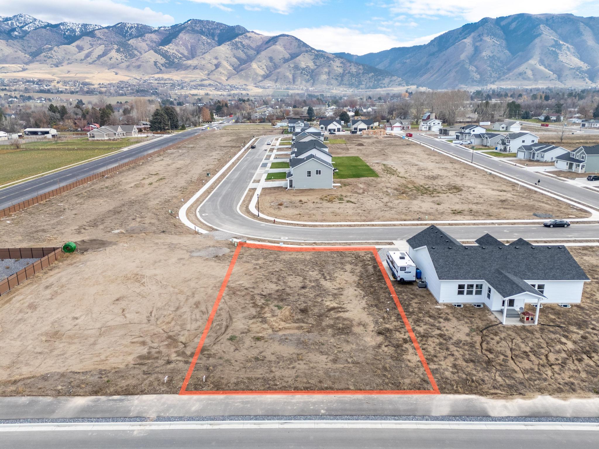 Aerial view of residential area featuring a mountainous background and property boundaries highlighted