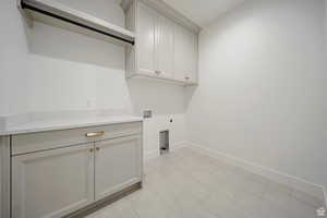 Washroom featuring cabinet space, hookup for a washing machine, and hookup for an electric dryer