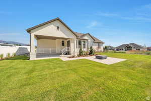 Rear view of property with stucco siding, a porch, and a patio area