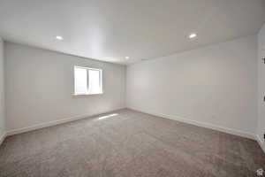 Empty room featuring light colored carpet and recessed lighting