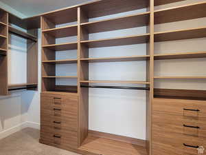 Primary closet with a custom shelving and drawer system.