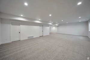 Finished below grade area featuring light carpet and recessed lighting