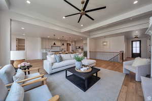 Great room featuring light wood-style floors, recessed lighting, ceiling fan, and a tray ceiling