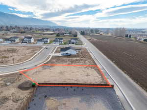 Aerial perspective of suburban area with property parcel outlined and mountains