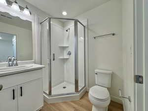 Bathroom featuring vanity, light wood-type flooring, and a stall shower