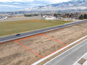 Aerial view of property's location with a mountainous background and property parcel outlined