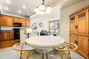 Dining area featuring recessed lighting, a chandelier, and dark carpet
