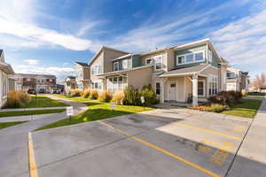 Traditional-style house featuring uncovered parking, a front lawn, and a residential view