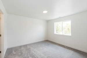 Spare room featuring light carpet and baseboards