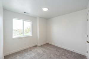 Carpeted empty room featuring baseboards