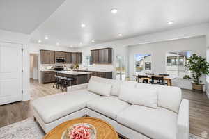 Living area with light wood-type flooring and recessed lighting