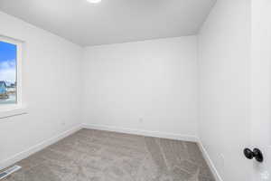 Carpeted spare room with baseboards