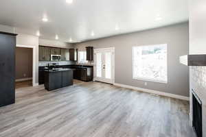 Kitchen with a kitchen island, healthy amount of natural light, a tile fireplace, open floor plan, and recessed lighting