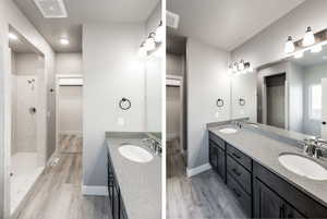 Bathroom with a walk in closet, double vanity, two vanities, and a shower stall