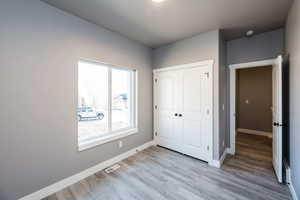 Unfurnished bedroom featuring a closet and light wood-style floors
