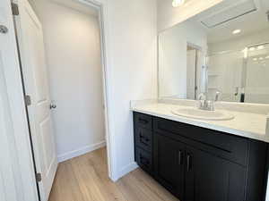 Bathroom with vanity, a stall shower, and light wood finished floors