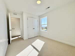 Unfurnished bedroom featuring carpet and a closet