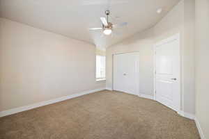 Unfurnished bedroom with lofted ceiling, carpet floors, ceiling fan, and a closet