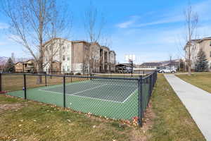 View of tennis court with a residential view